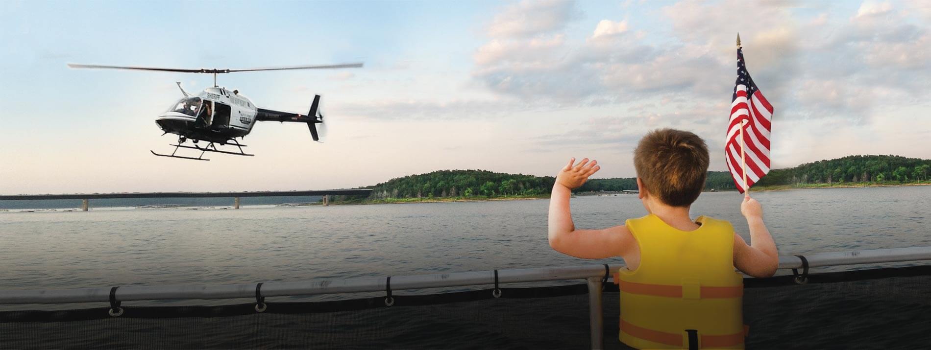 Young boy waving American flag at Baxter County Sheriff Helicopter